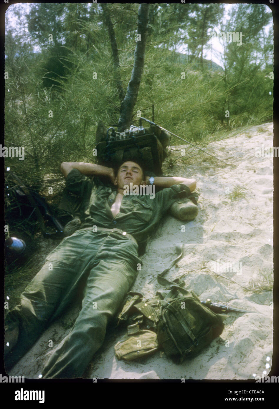 soldier resting next to radio RTO US Marines Vietnam War 1965 radio man operator Stock Photo