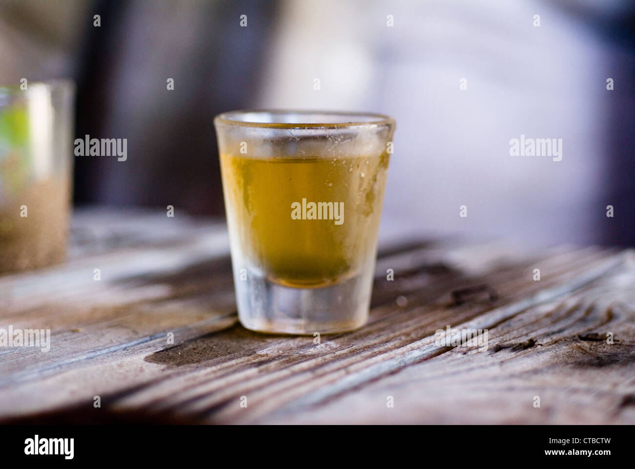 Single shot glass of whiskey on a wooden table Stock Photo