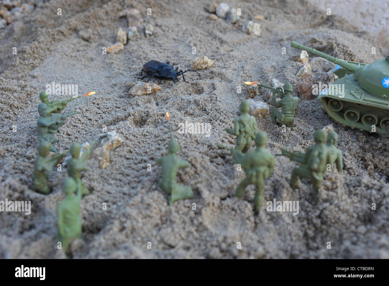 A group of green army men toys fighting a big bug Stock Photo