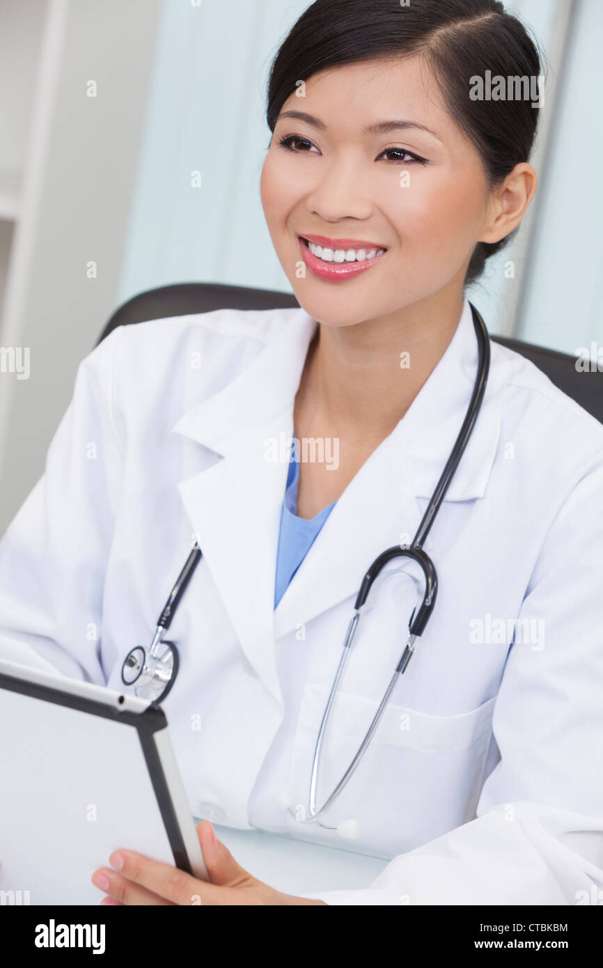 A Chinese Asian female medical doctor using a tablet computer in her
