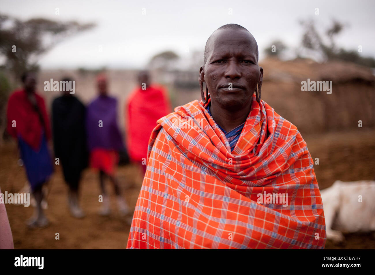 Maasai Tribesman with others in soft focus Stock Photo - Alamy.