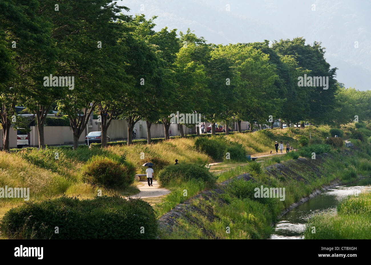 The quiet path along the bank of the Kamo River in Kyoto, Japan, is a popular and peaceful place to walk, cycle or picnic Stock Photo