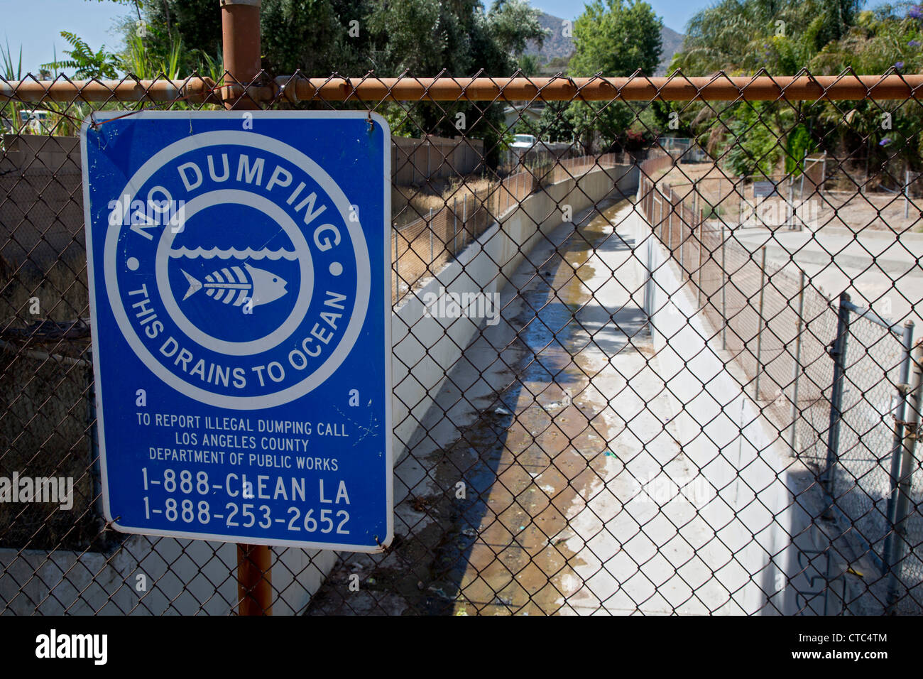 Sylmar, California - A sign warns against illegal dumping in a canal that drains storm water to the Pacific Ocean. Stock Photo
