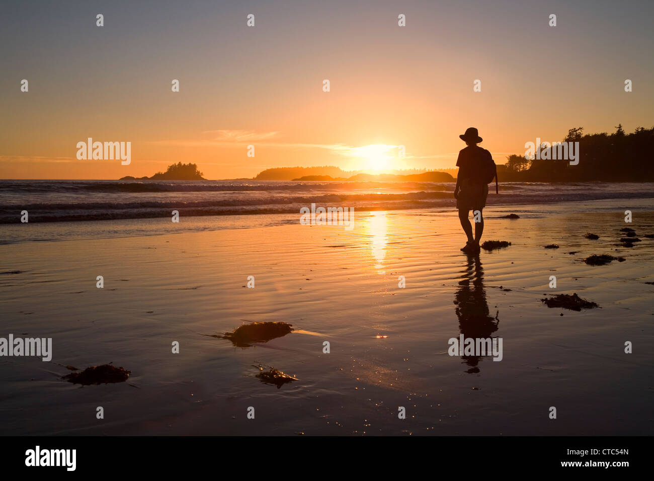 Woman watching sunset on Chesterman Beach, Pacific Rim national park reserve, Vancouver island, Canada Stock Photo