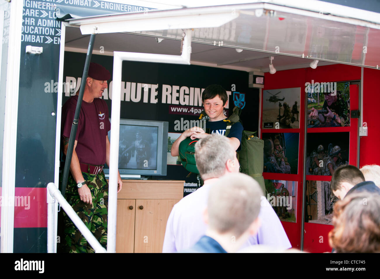 UK parachute regiment display teaching young boy how to wear a