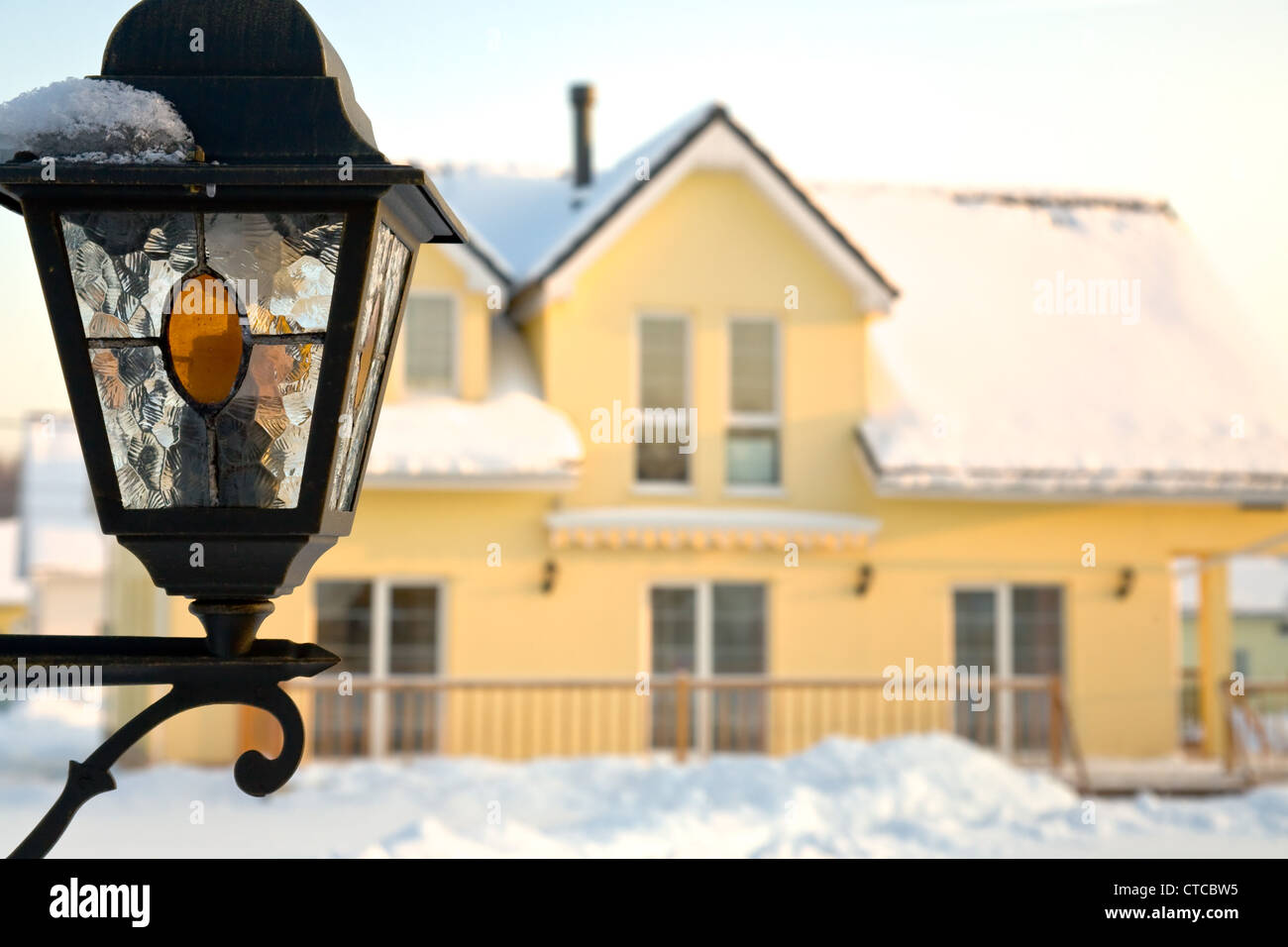 wall-mounted glass lantern with county house in background Stock Photo