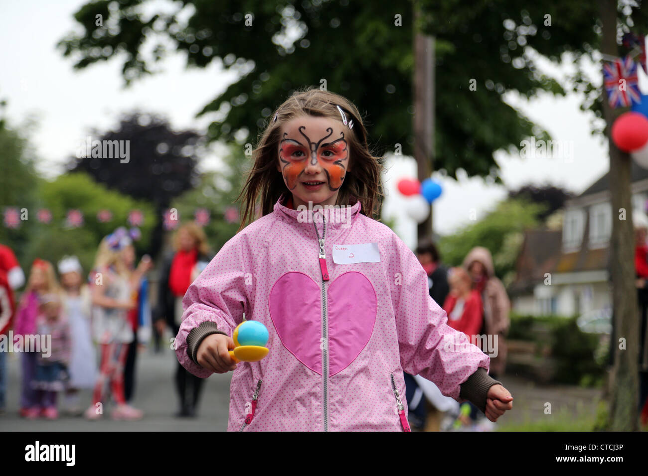 Girl With Face Paint Participating In Egg and Spoon Race At A Street