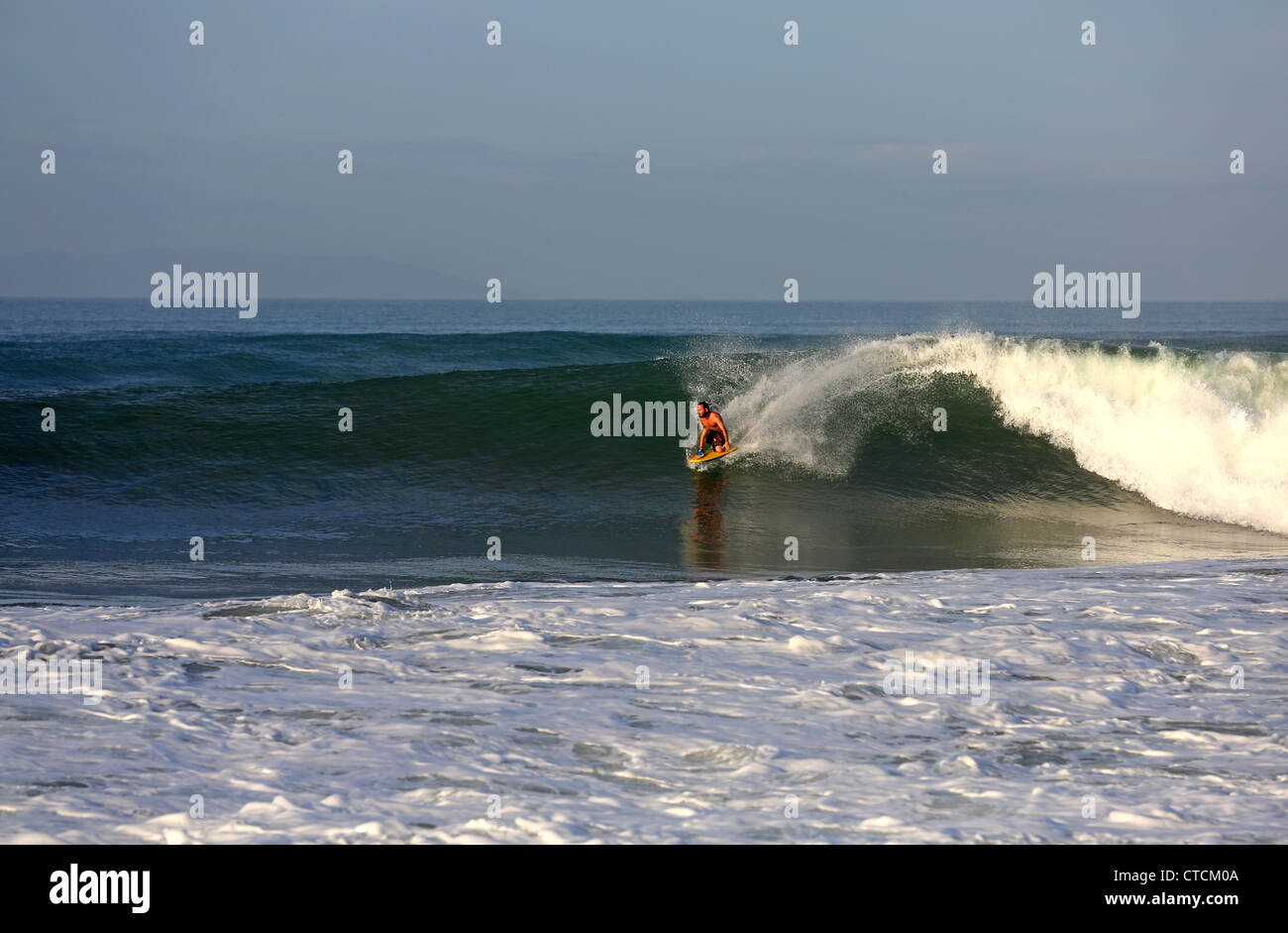 Man body surfing a large wave in West Java, Indonesia. Stock Photo