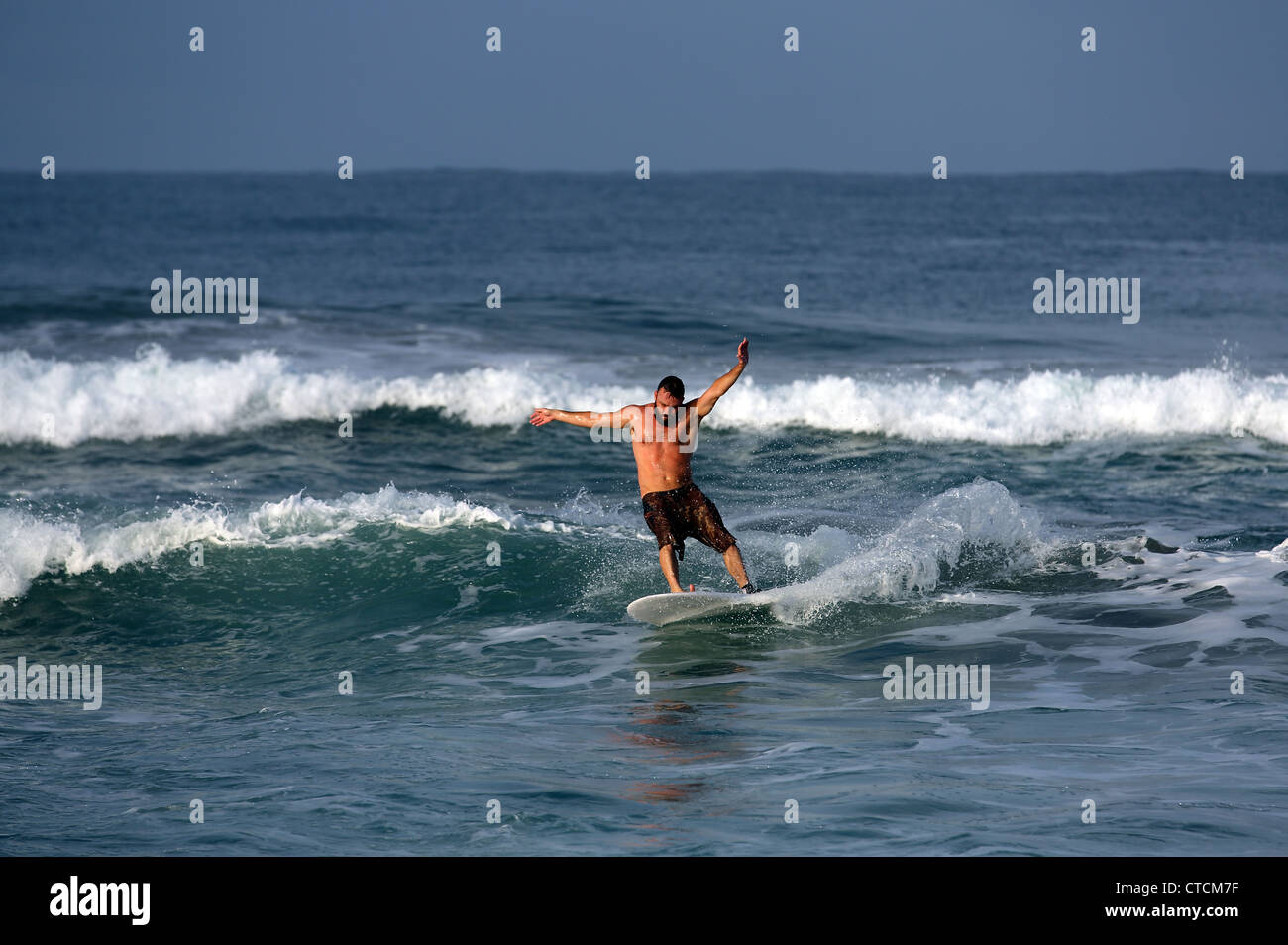 Bearded man surfing a wave in Sumatra, Indonesia. Stock Photo