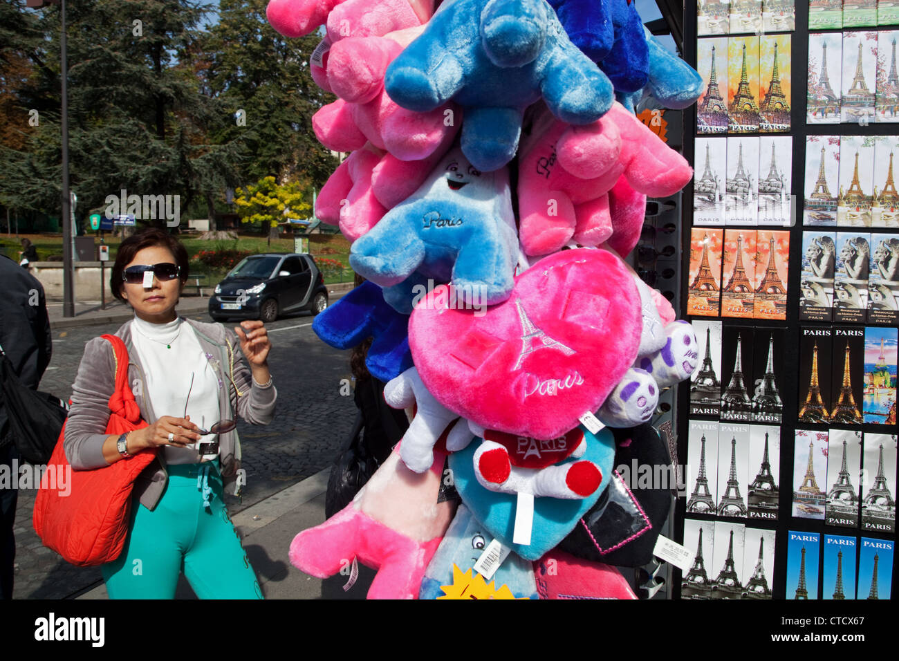 An Asian tourist woman (probably Chinese) shops for sunglasses near the Eiffel Tower in Paris, France. Stock Photo