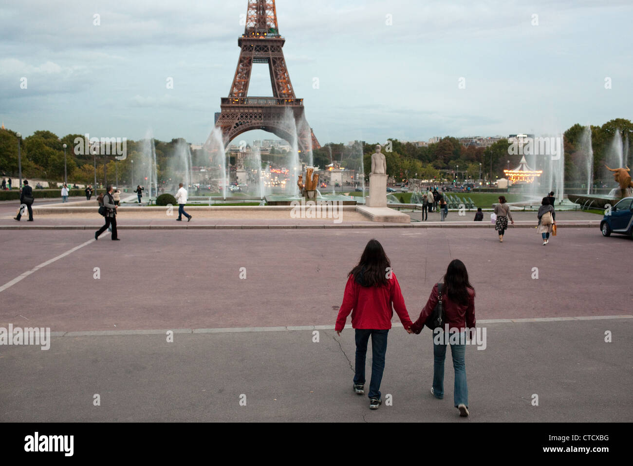 A romantic scene when a couple holds hands near the Eiffel Tower in Paris, France. Stock Photo