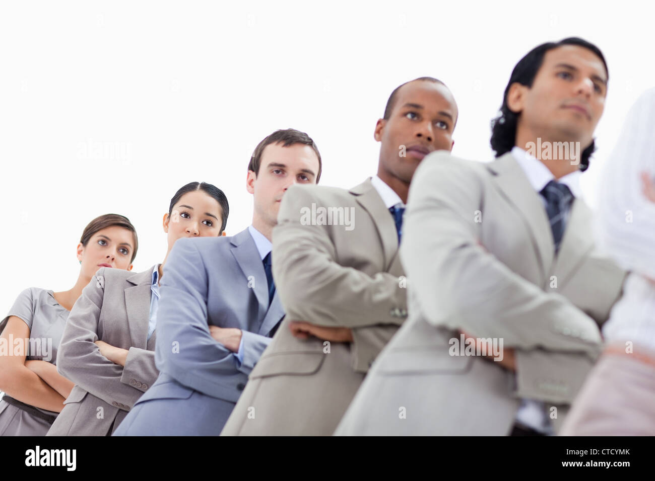 Low-angle shot of people dressed in suits crossing their arms in a single line Stock Photo