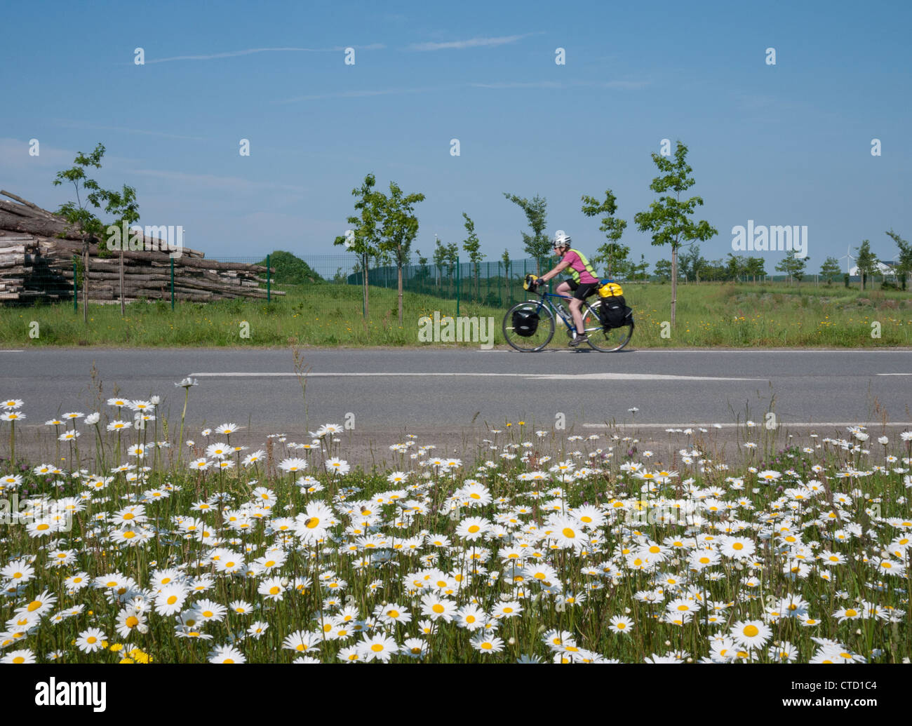 Lady cycling touring along a French road Stock Photo