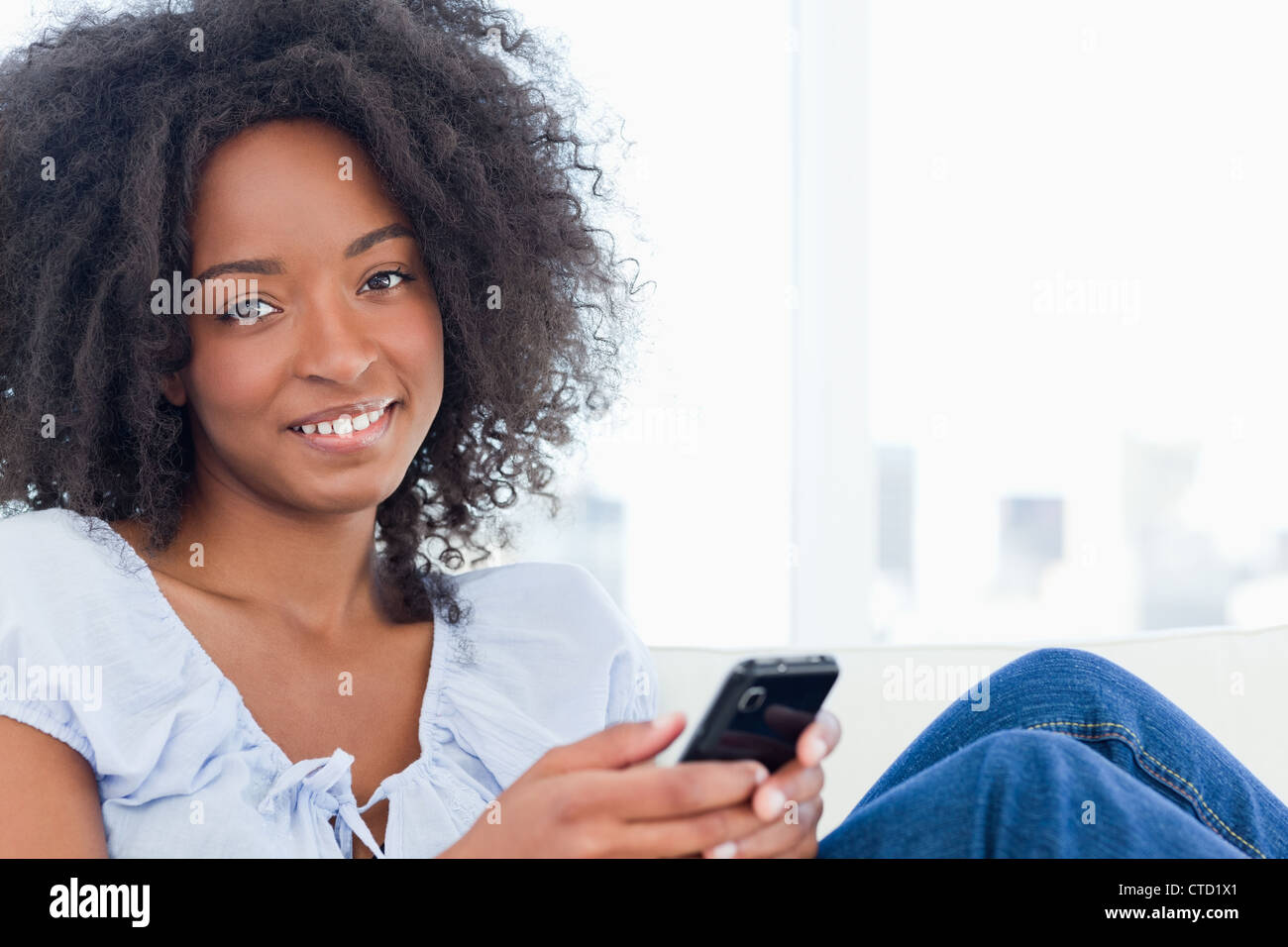 Portrait of a fuzzy hair woman writing a text message Stock Photo