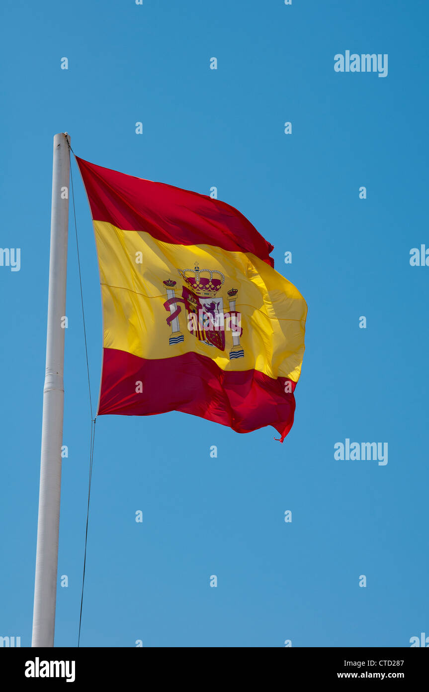 Spanish national flag flying from a pole with a blue sky background Stock Photo