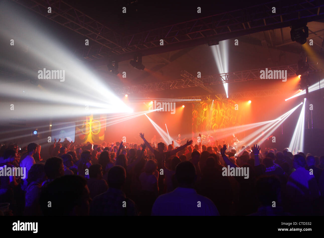 concert gig stage lights crowd arms in air crowd shot Stock Photo