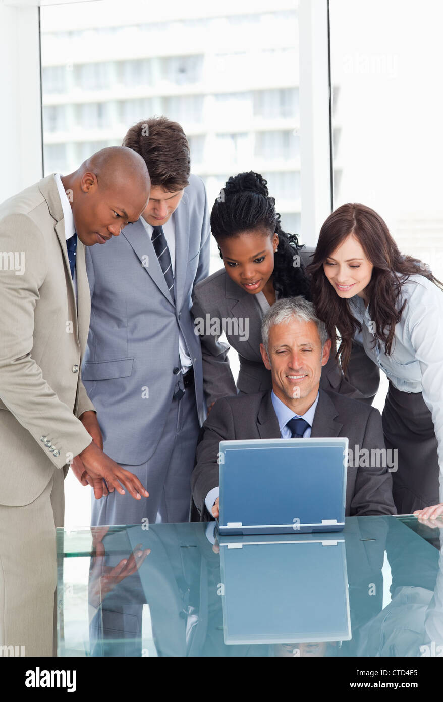 Business team earnestly listening to their mature and smiling manager Stock Photo