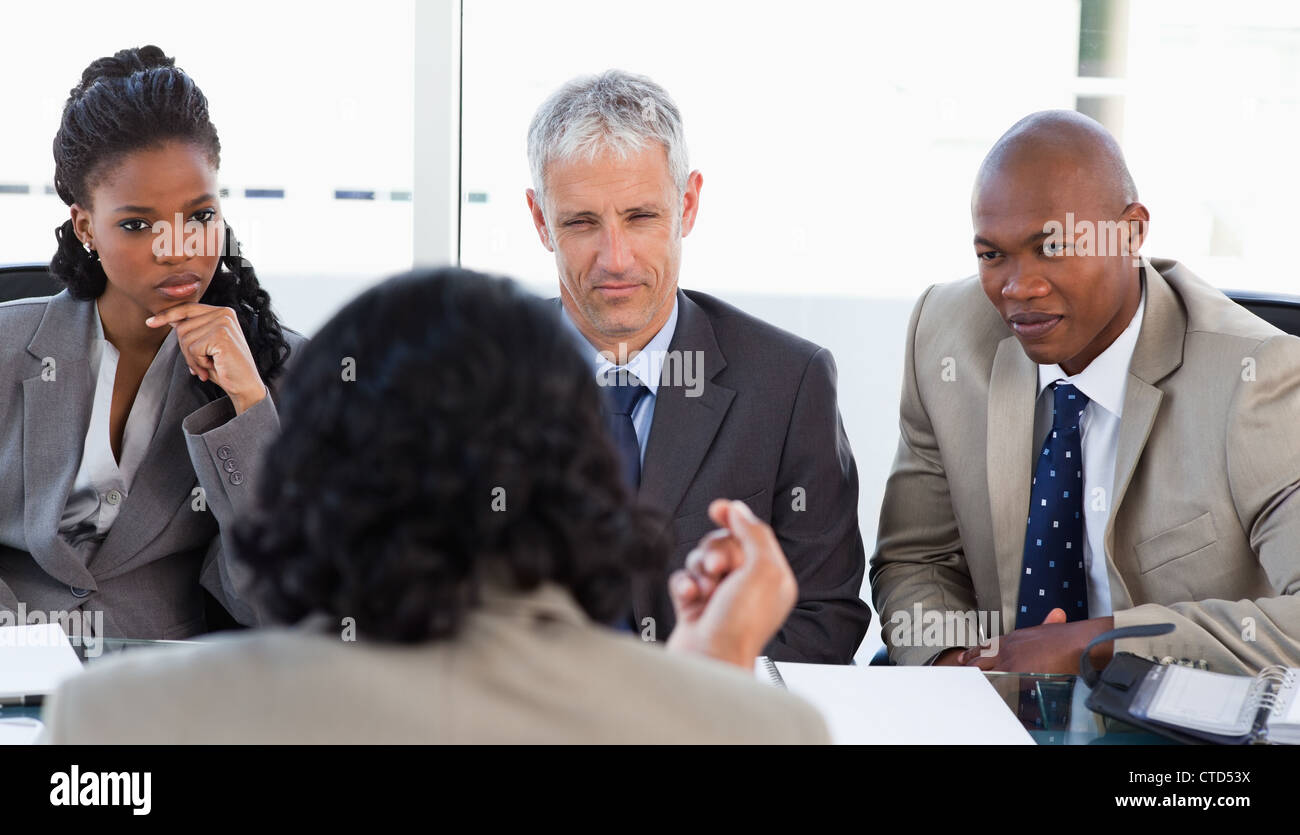 A business team is earnestly listening to an associate Stock Photo