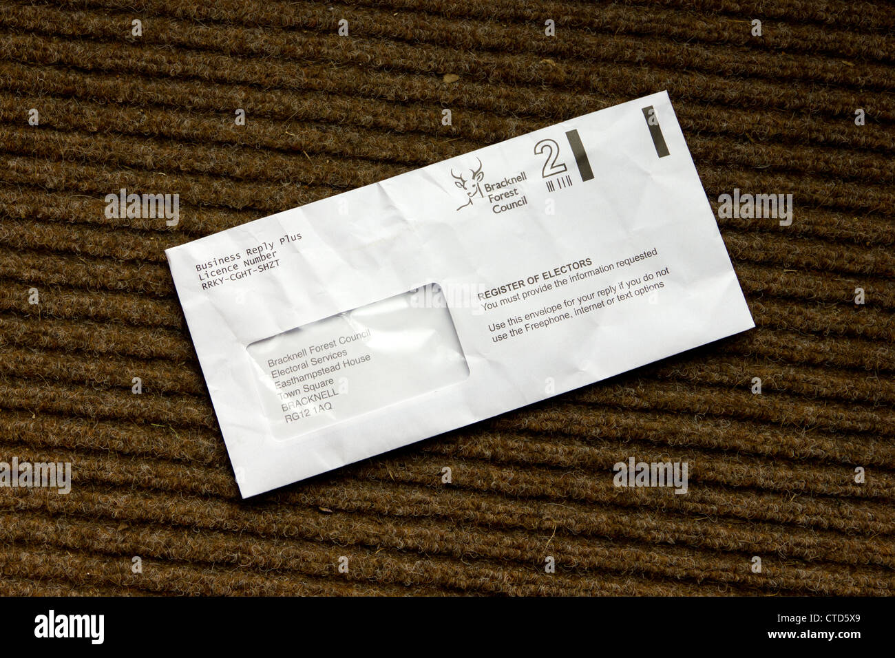 Crumpled letter on a doormat Stock Photo