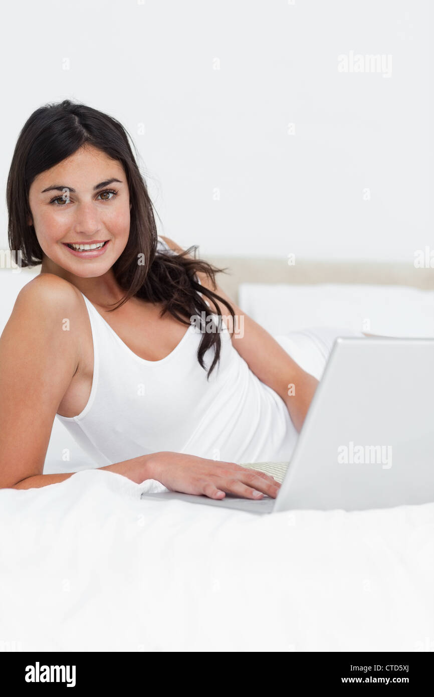 Portrait of a smiling brunette using her laptop Stock Photo - Alamy