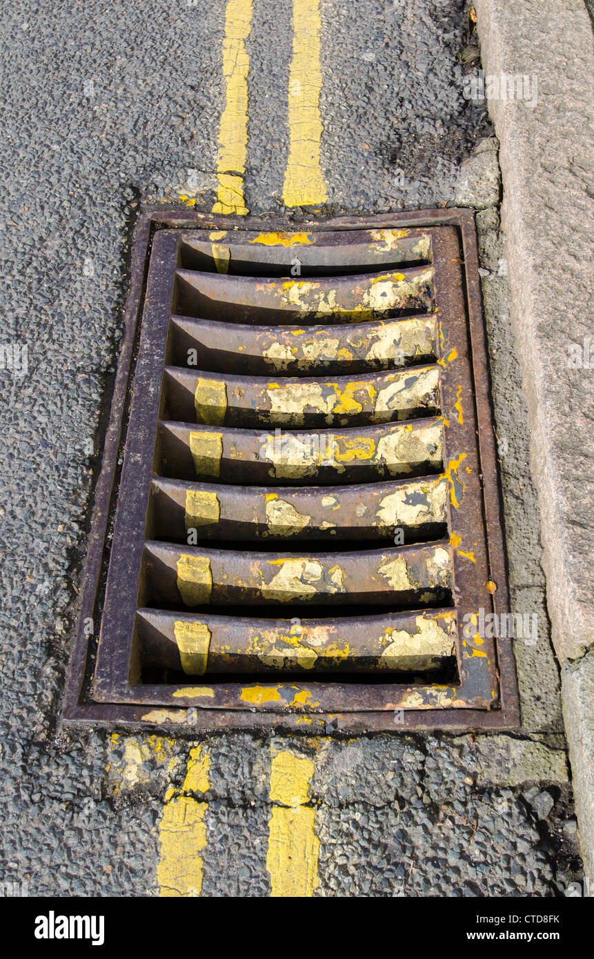 A drain grid covered in various yellow lines. Stock Photo