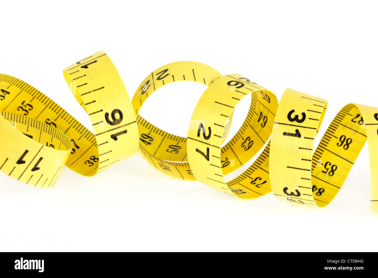 Yellow coiled tape measure on a white background Stock Photo