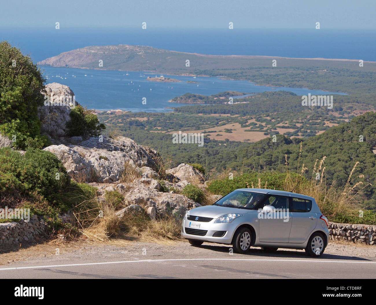 VIEW FROM MOUNT TORO OF FORNELLS WITH  SUZUKI HIRE CAR IN FORGROUND  MENORCA SPAIN Stock Photo