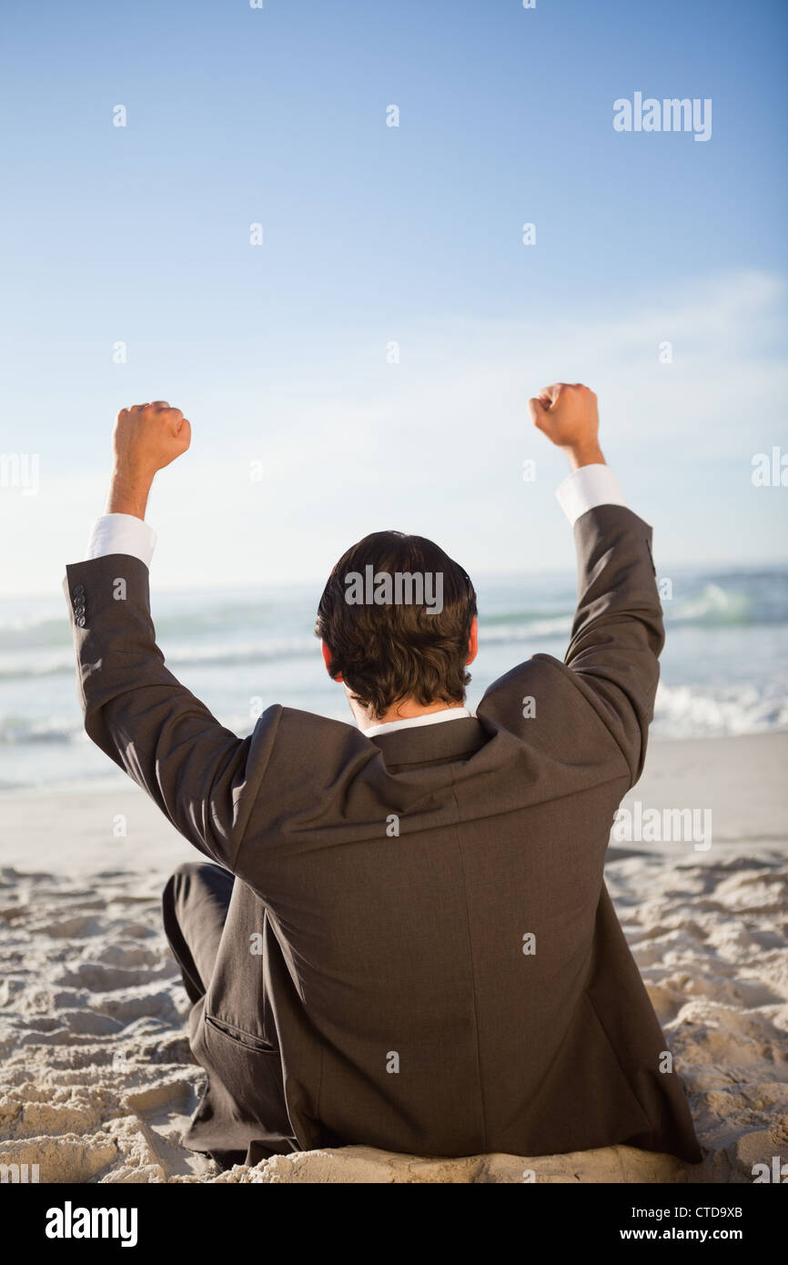 Rear view of a young businessman raising his arms Stock Photo - Alamy