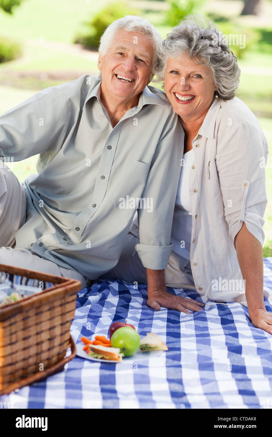Smiling couple looking at the camera having a picnic Stock Photo