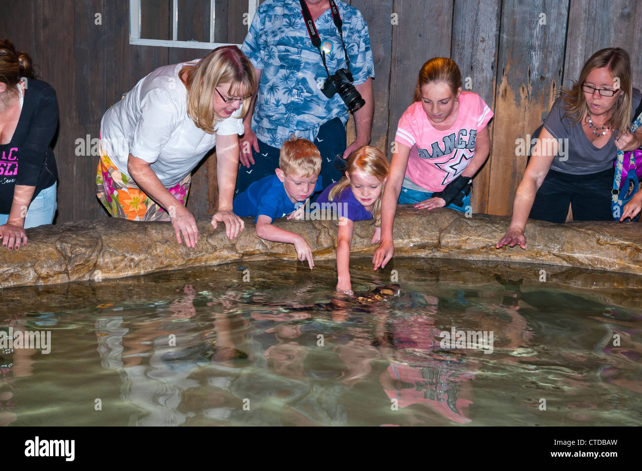 Visitors playing with fish in Adventure aquarium , Camden,New Jersy, USA Stock Photo