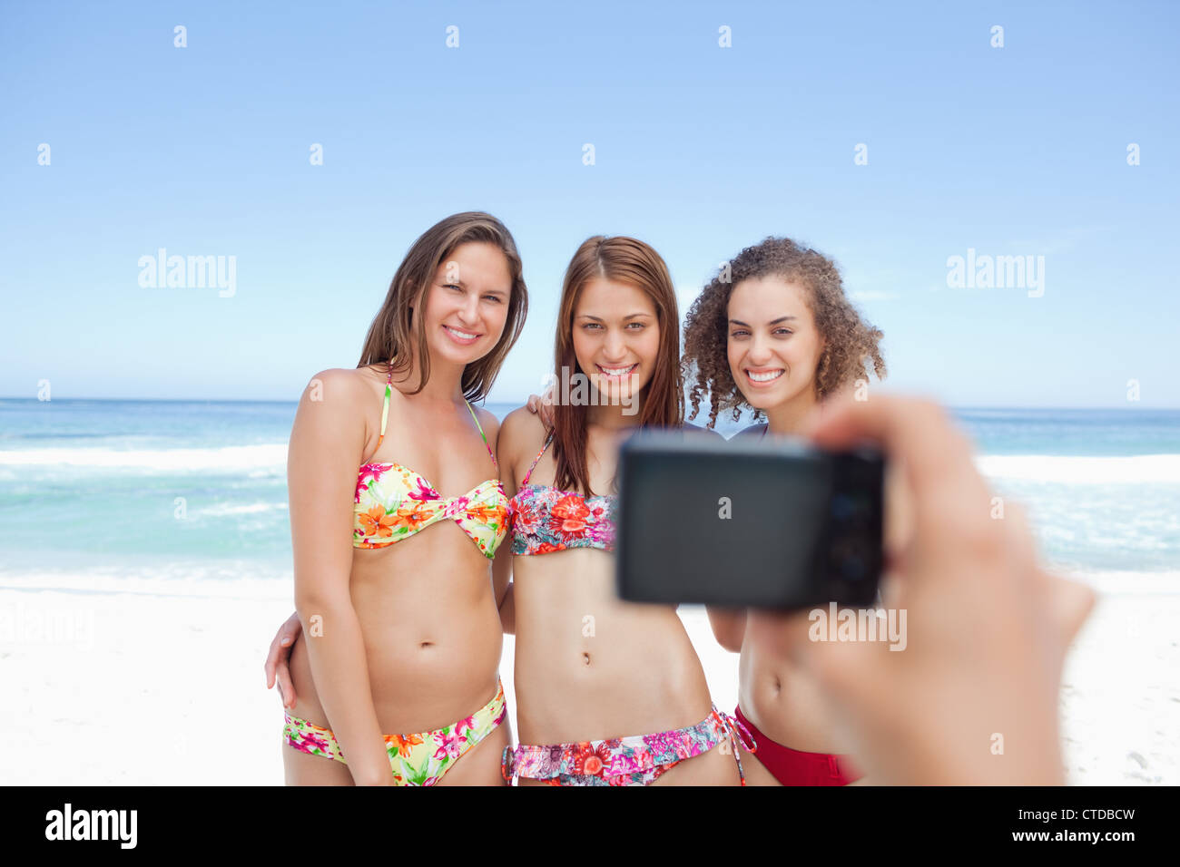 Somebody taking a photo of three posing friends Stock Photo