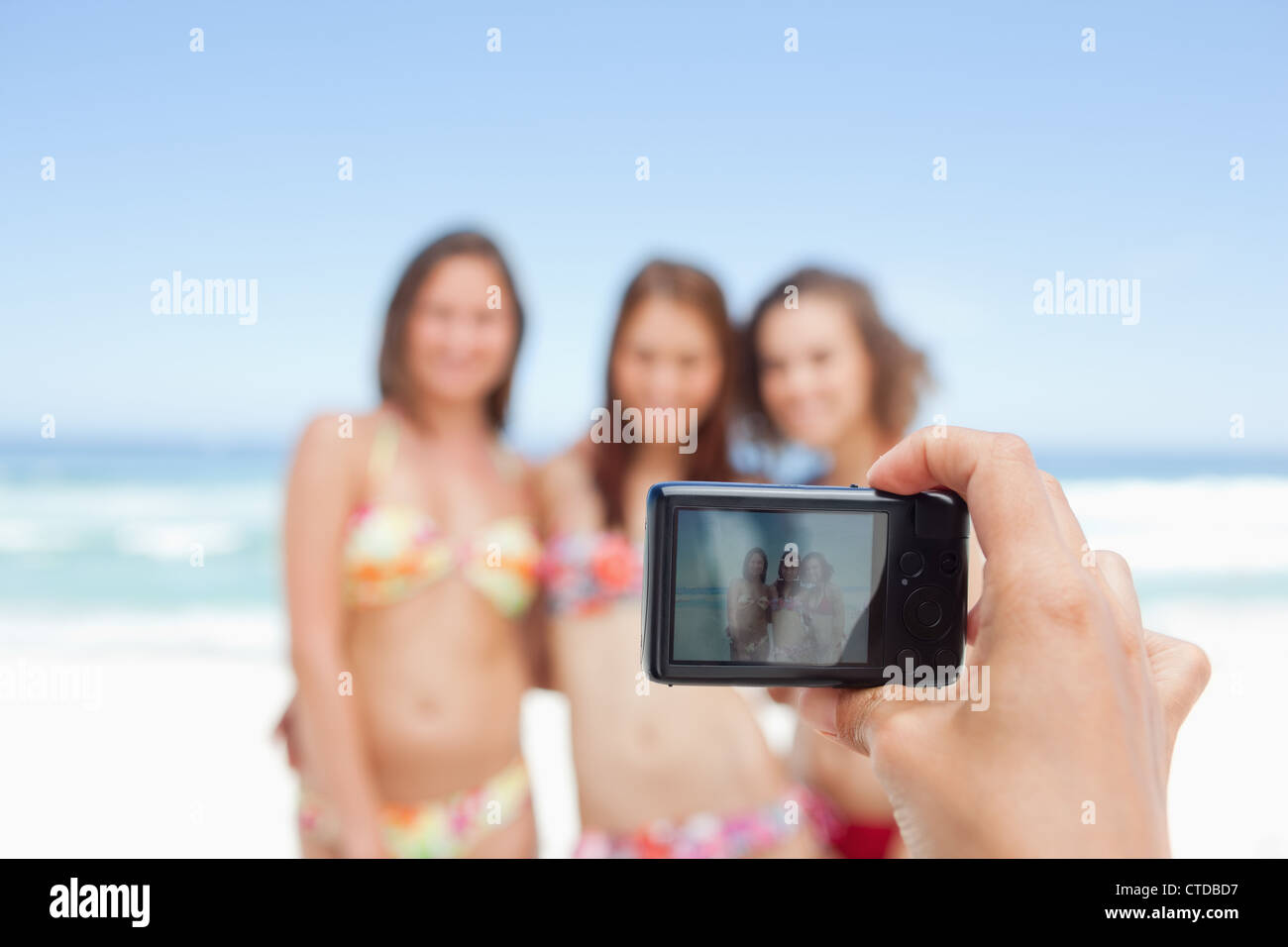 Somebody taking a photo of three friends who are posing Stock Photo