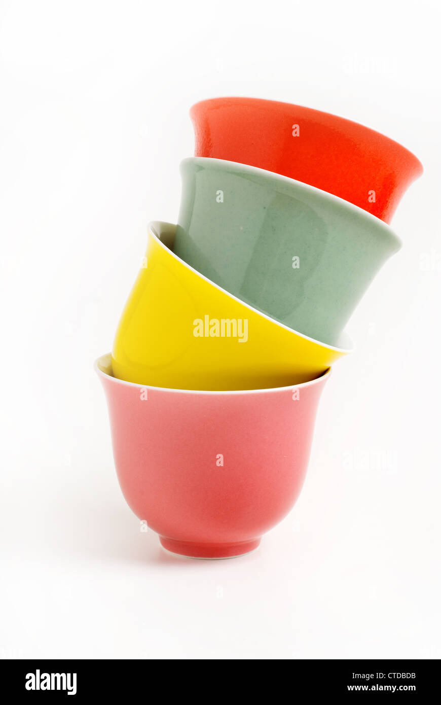 Colorful Chinese crockery tea cups piled in a stack. Stock Photo