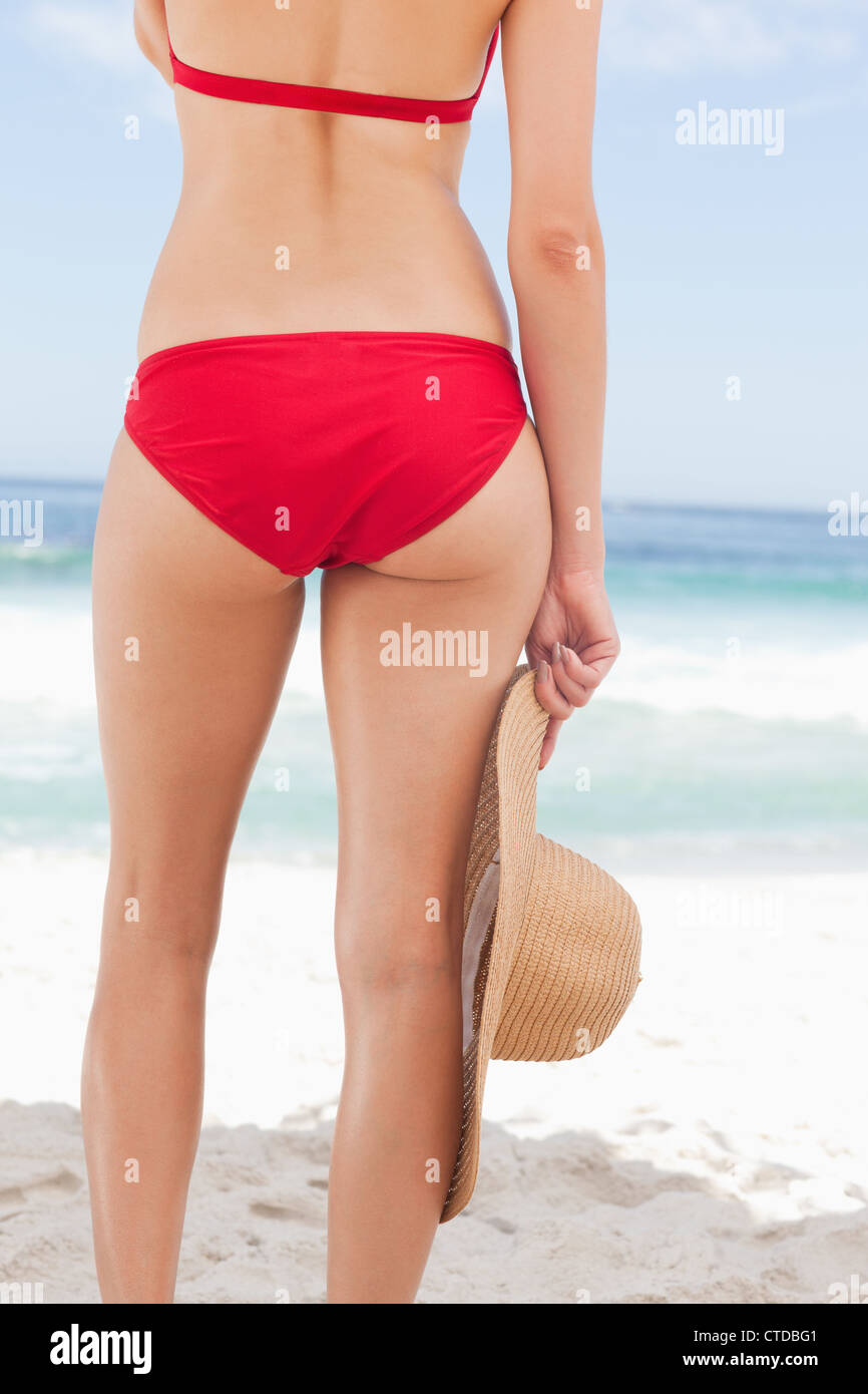 Woman in a red bikini holding a hat Stock Photo