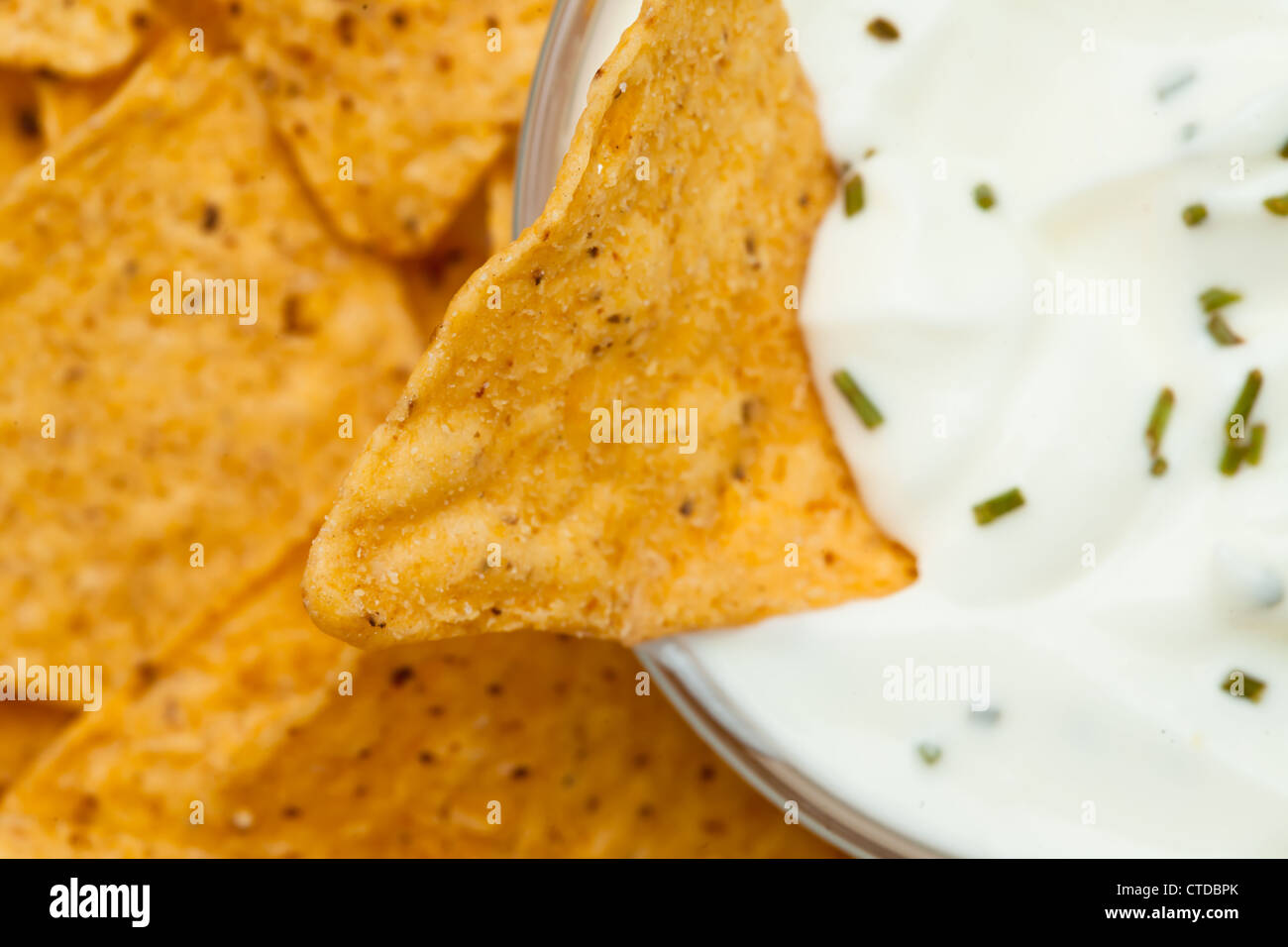Close up of a nacho dipped into a bowl of dip Stock Photo