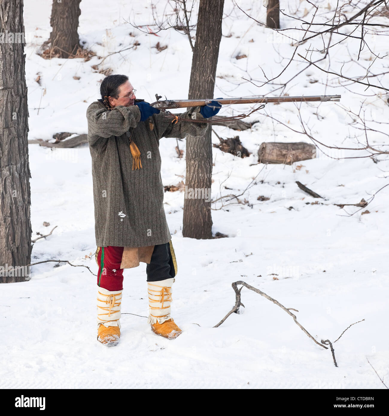 Metis in traditional costume shooting flintlock musket at Festival du Voyageur, Winnipeg, Manitoba, Canada Stock Photo