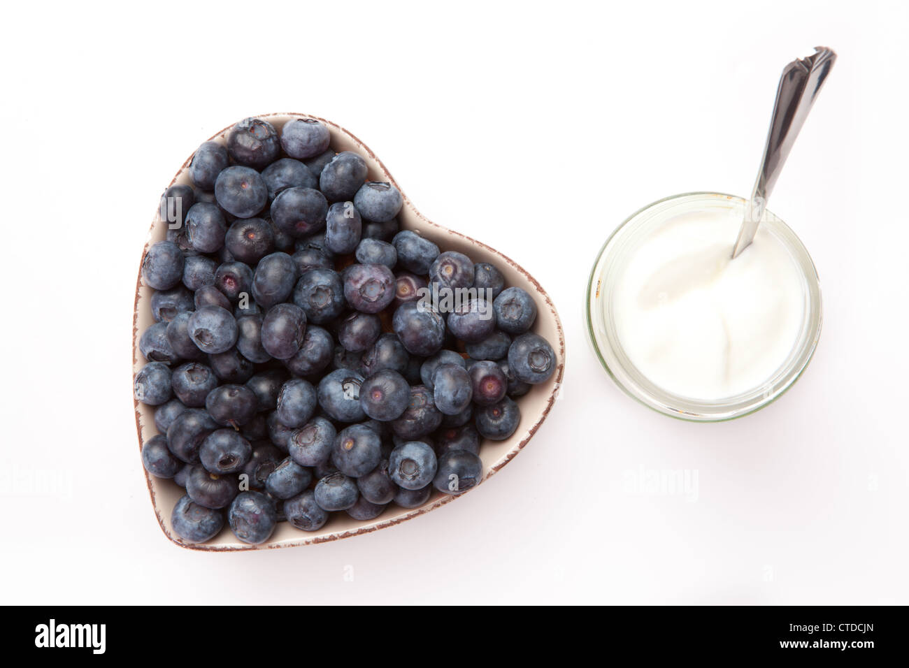 White yogurt and blueberries in a heart shaped bowl Stock Photo