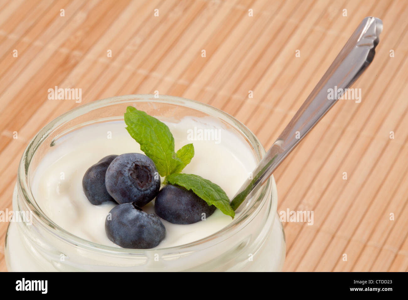Close up of four blueberries in a yogurt Stock Photo