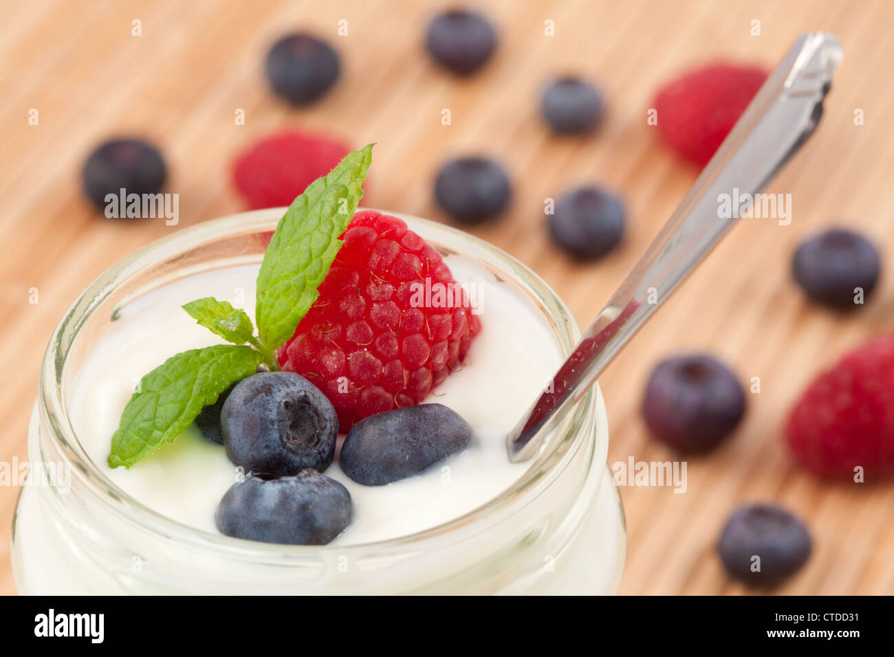 Close up of a pot yoghurt with mint blueberries and raspberry Stock Photo