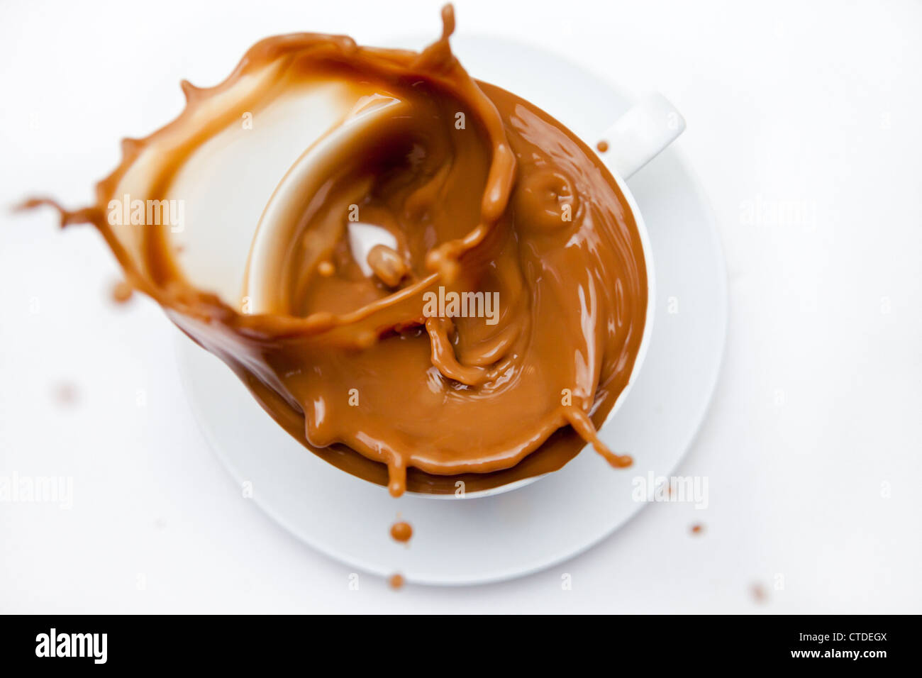 Overflowing cup of white coffee Stock Photo Alamy