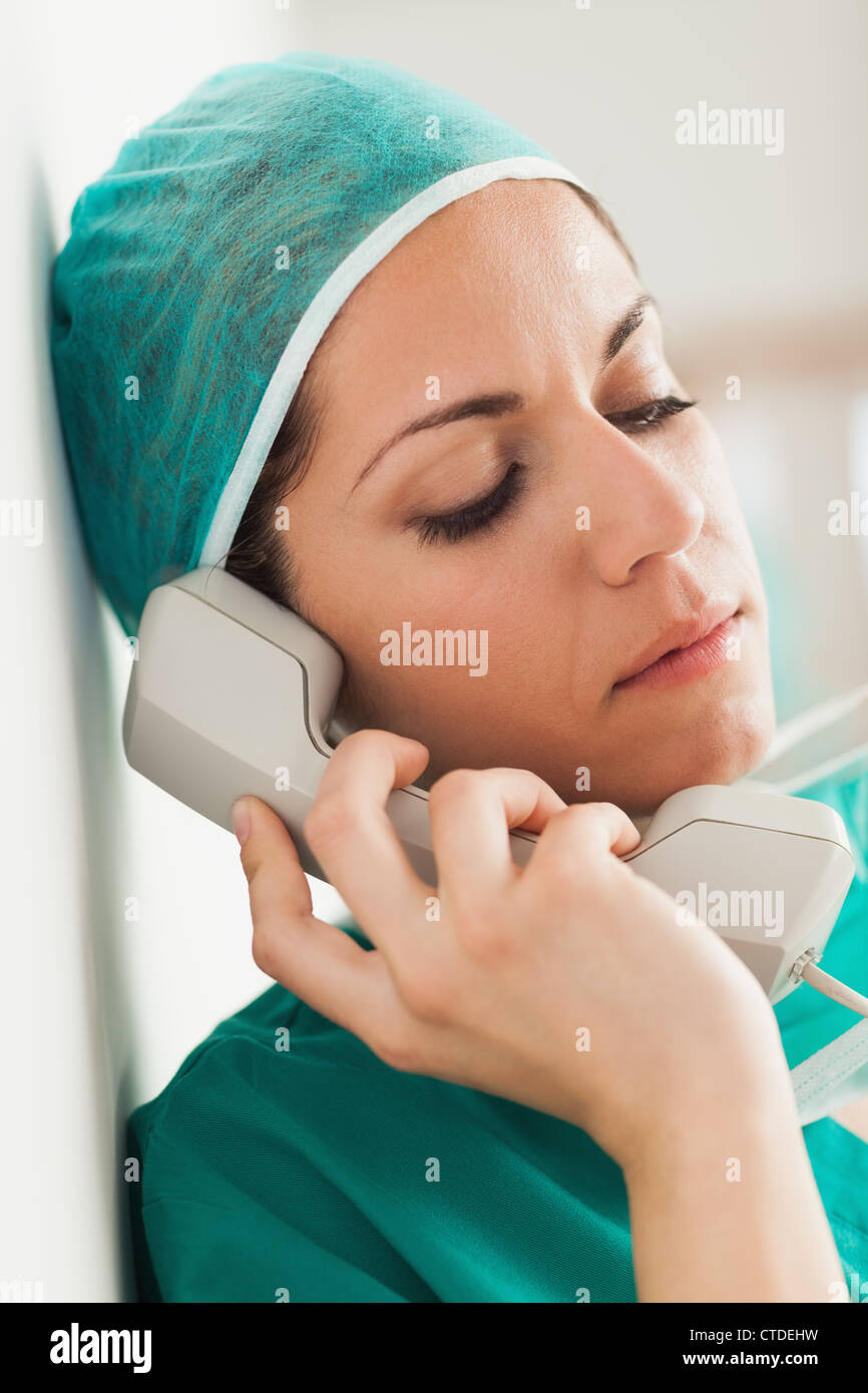 Sad female surgeon on the phone in a hallway Stock Photo