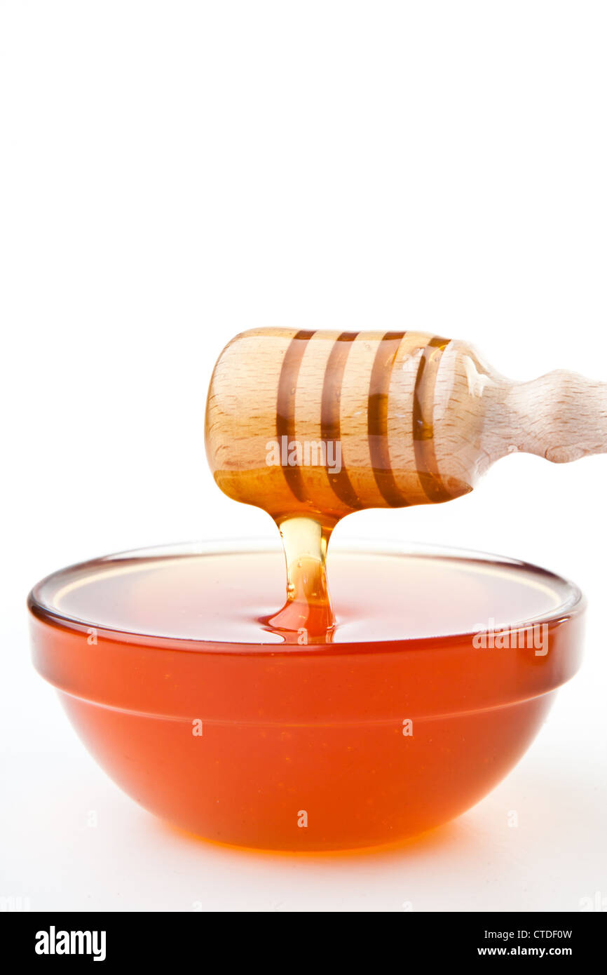 Honey dipper at horizontally  dropping a trickle of a honey Stock Photo
