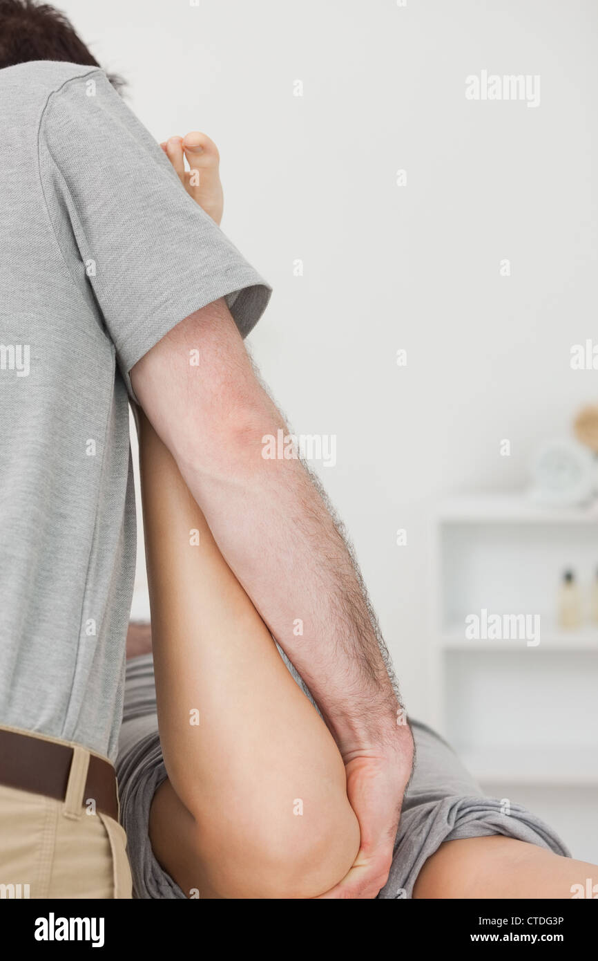 Physiotherapist manipulating the leg of a patient Stock Photo - Alamy