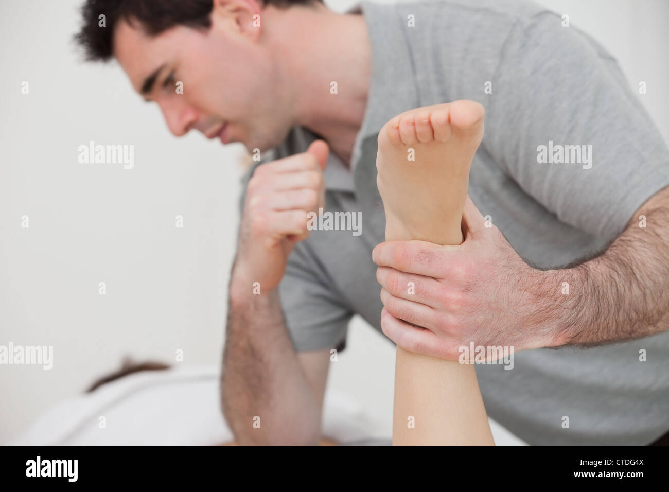 Physio manipulating the leg of a patient Stock Photo