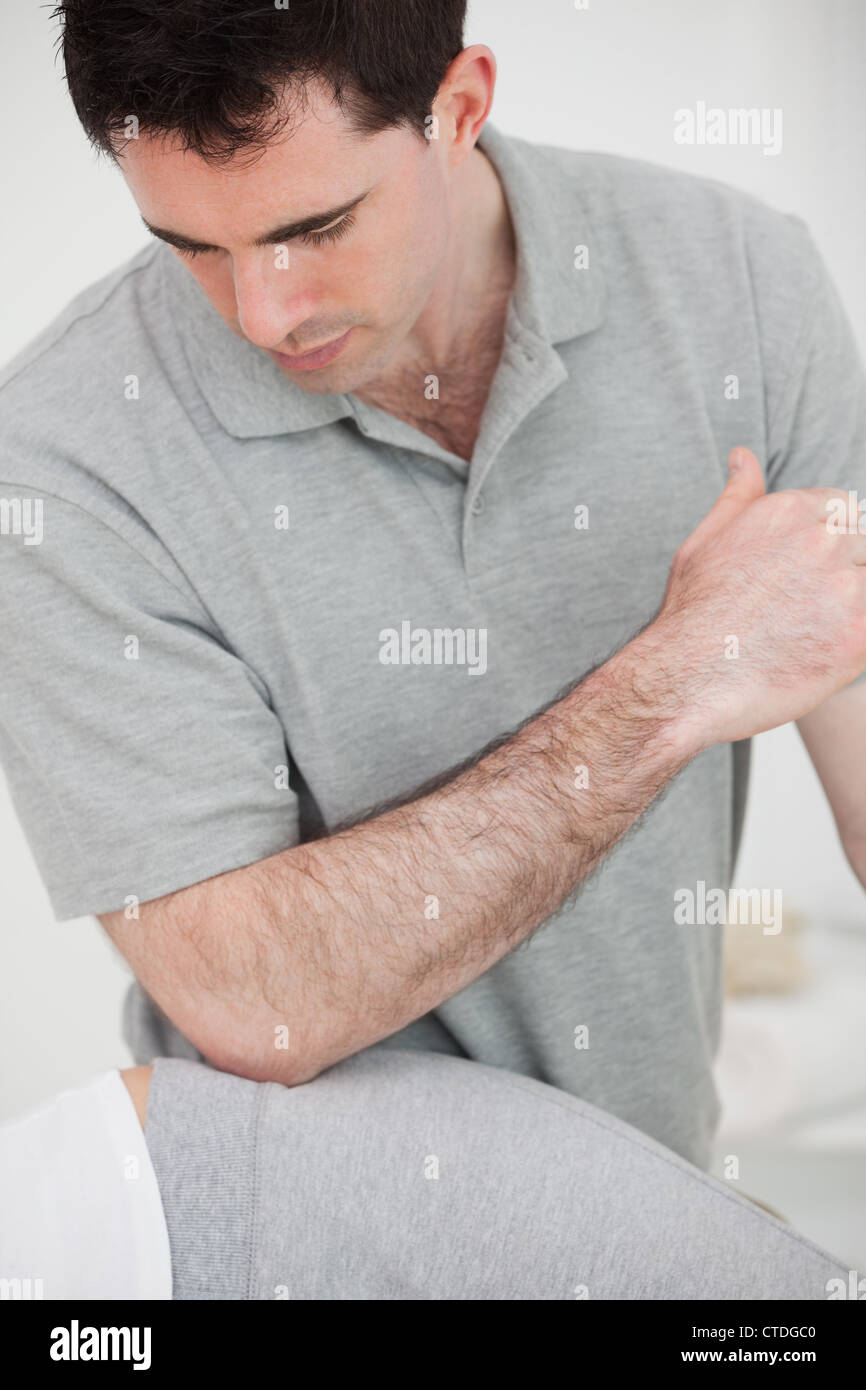 Physiotherapist using his elbow on the hip of a woman Stock Photo