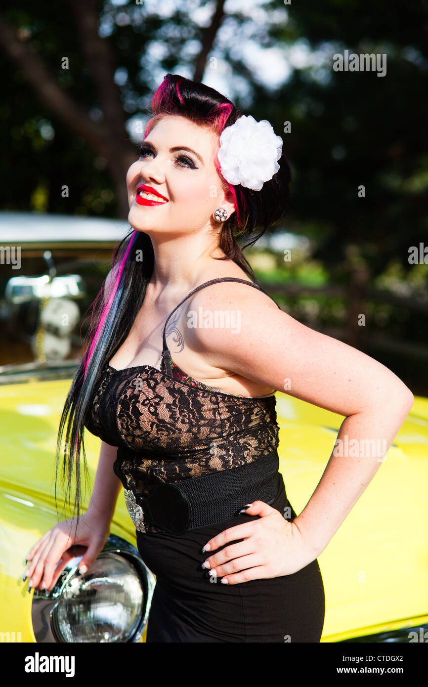 Female woman dressed in a rockabilly fashion posing next to a