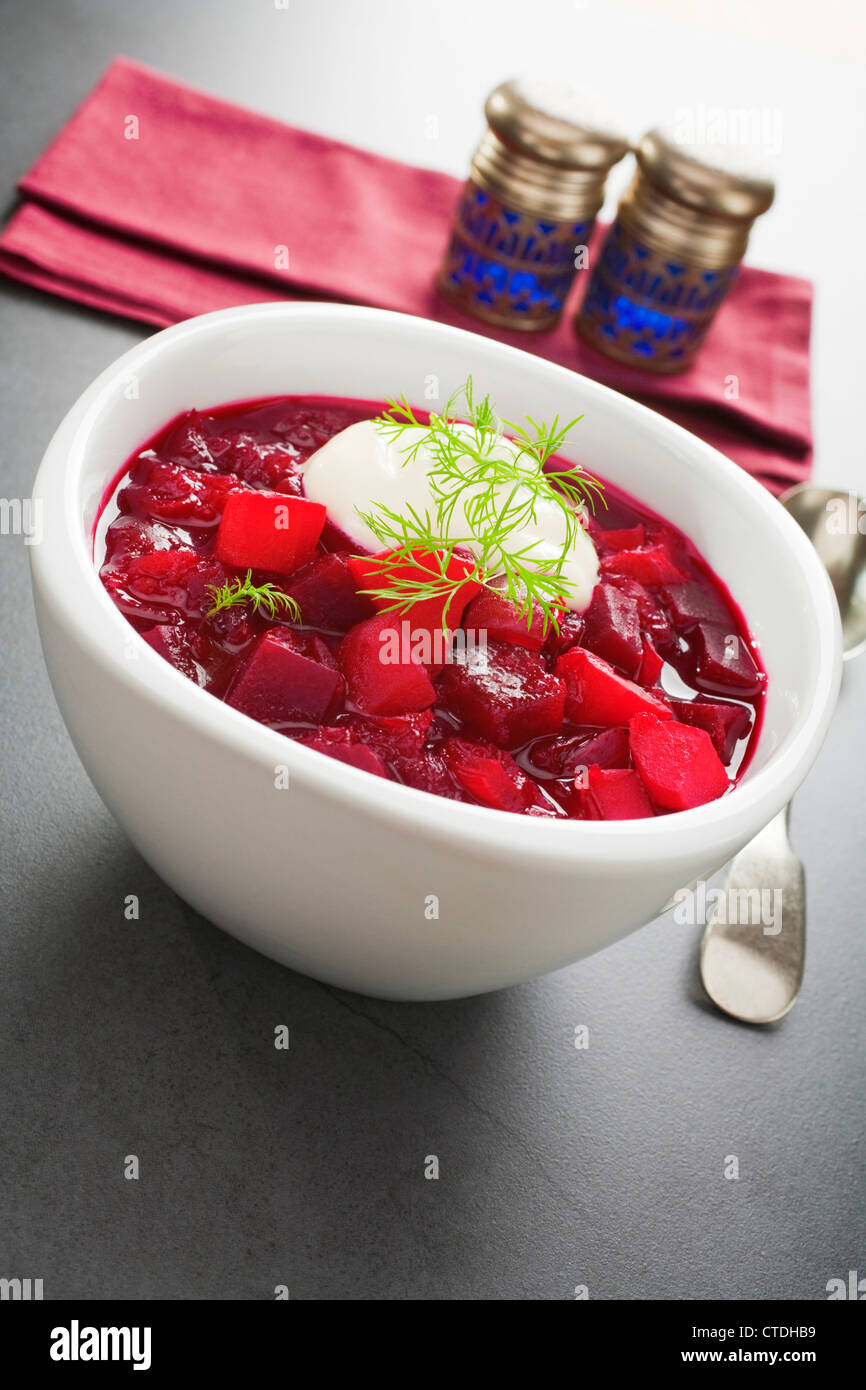 Traditional Russian soup borscht, made from beetroot, potatoes, onion, carrot and tomatoes, garnished with dill and sour cream. Stock Photo