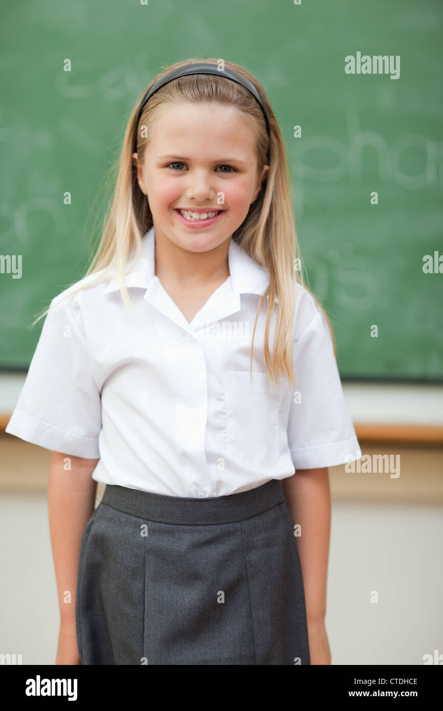 Smiling schoolgirl standing in front of blackboard Stock Photo - Alamy