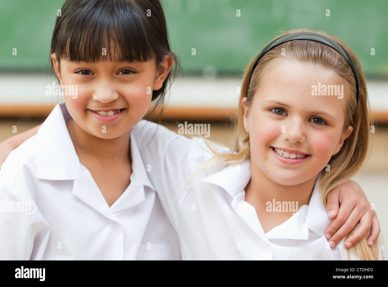 Smiling schoolgirls in front of blackboard Stock Photo - Alamy