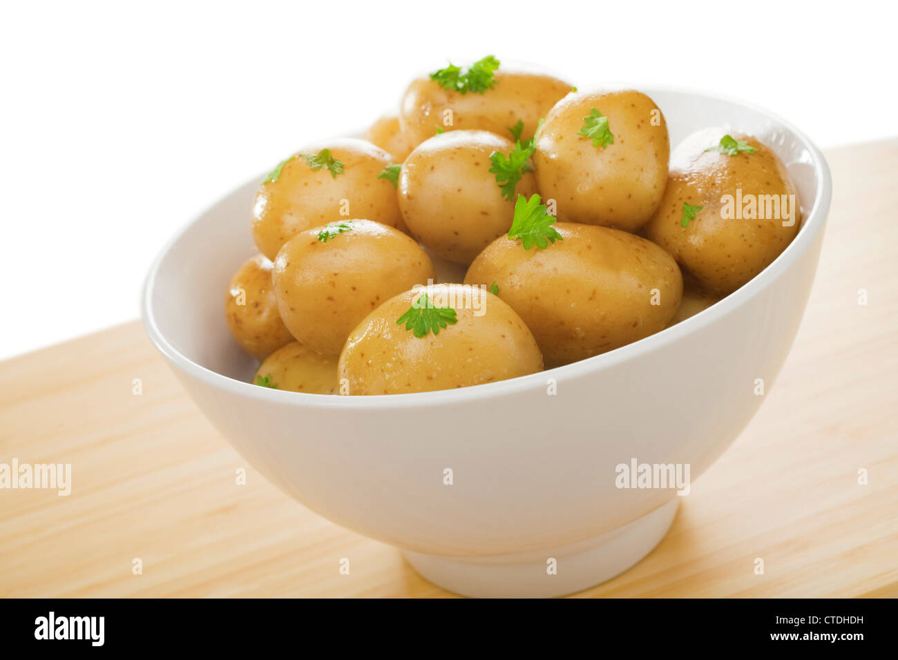A bowl of simple boiled new potatoes with parsley and butter. Stock Photo